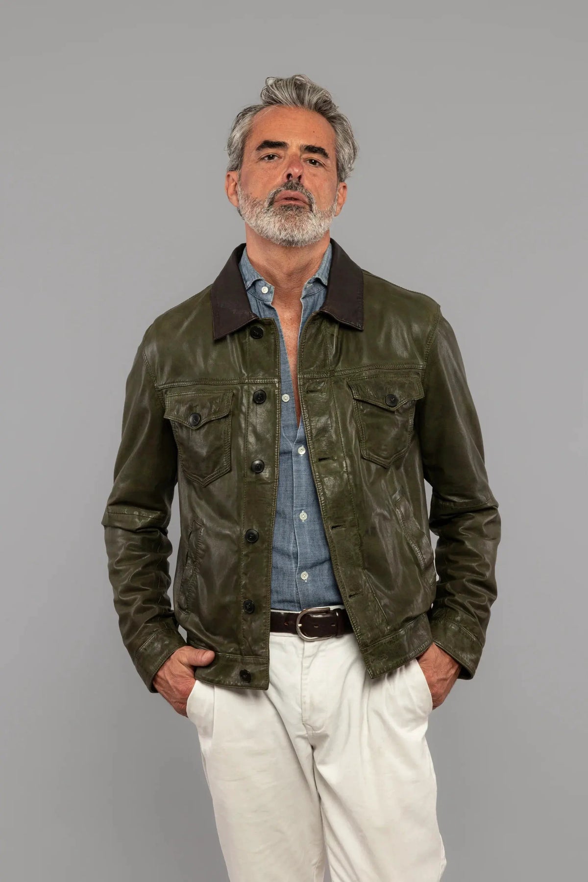 Giacca uomo in pelle verde con camicia denim e pantaloni chiari, moda elegante casual.
