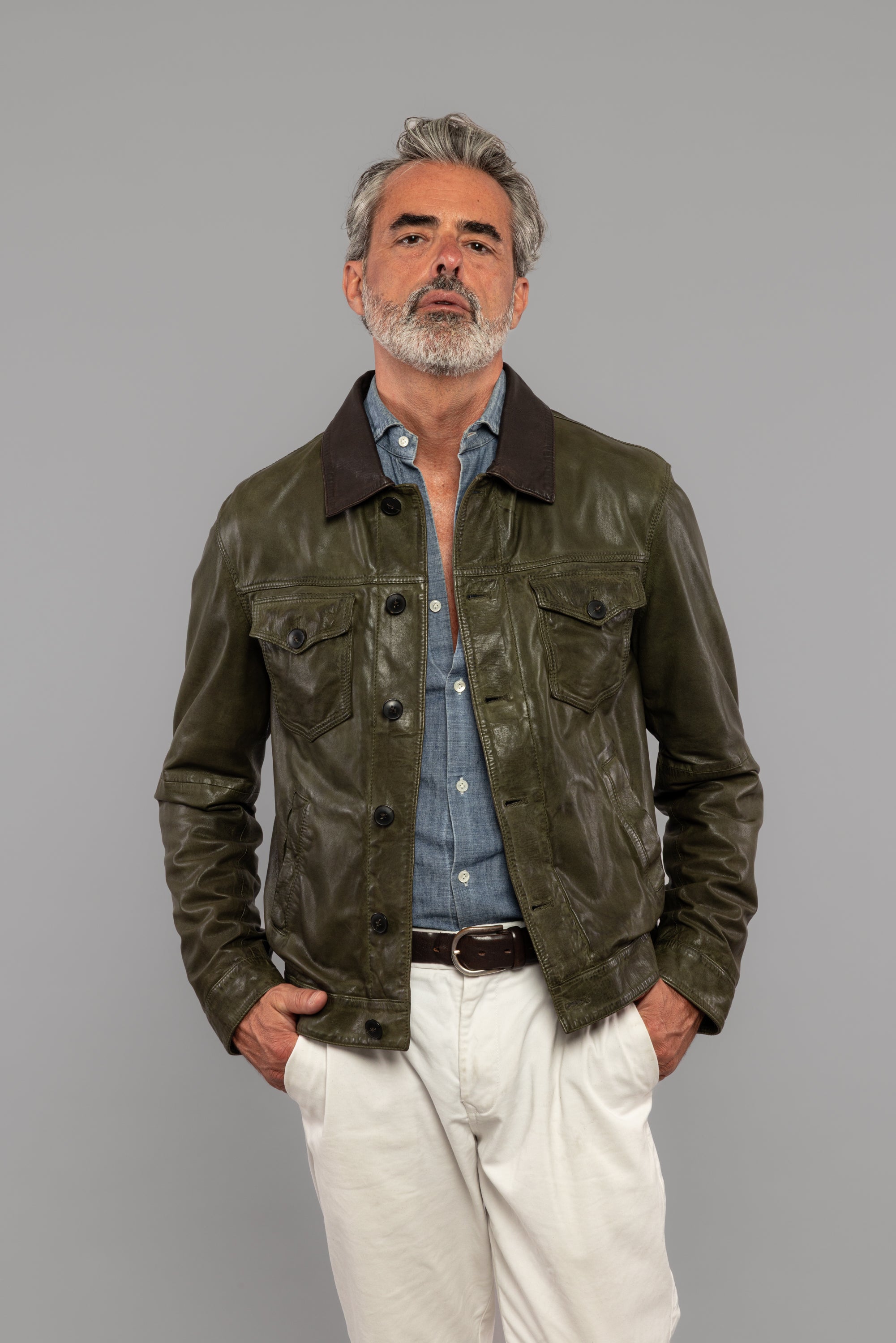 Giacca uomo in pelle verde con camicia denim e pantaloni chiari, moda elegante casual.