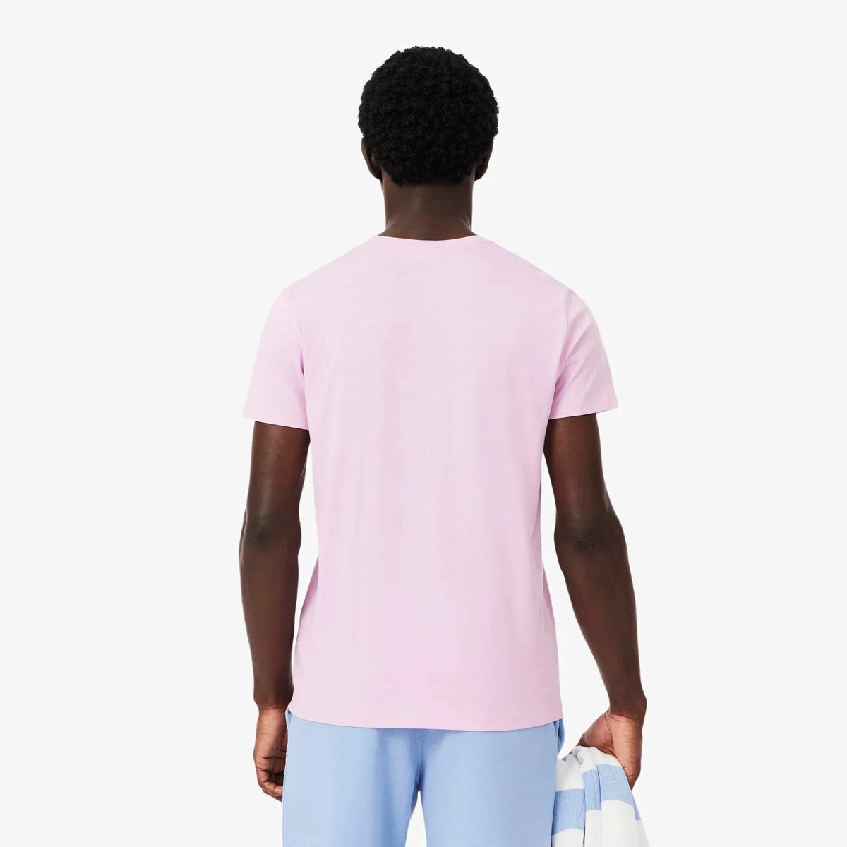 Uomo di spalle con t-shirt rosa e pantaloni azzurri, abbigliamento casual estivo
