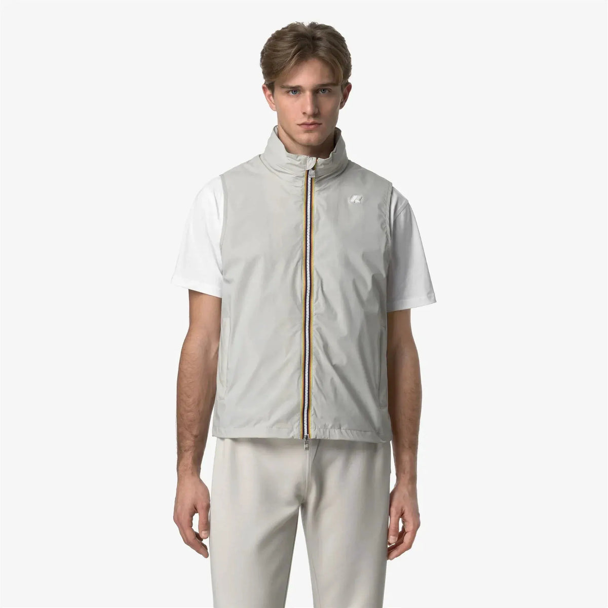 Gilet uomo grigio chiaro con zip a contrasto, indossato su t-shirt bianca, moda casual
