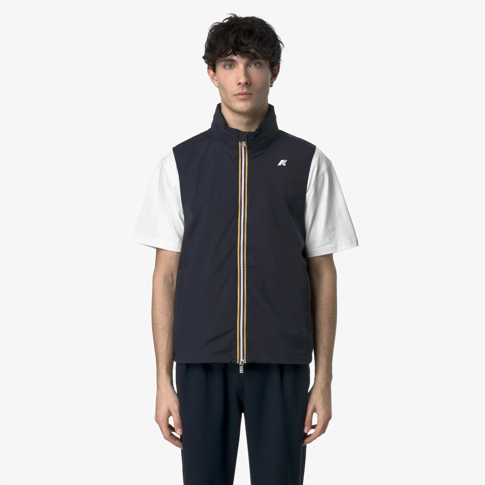 Gilet uomo blu con zip a contrasto, indossato su t-shirt bianca e pantaloni scuri