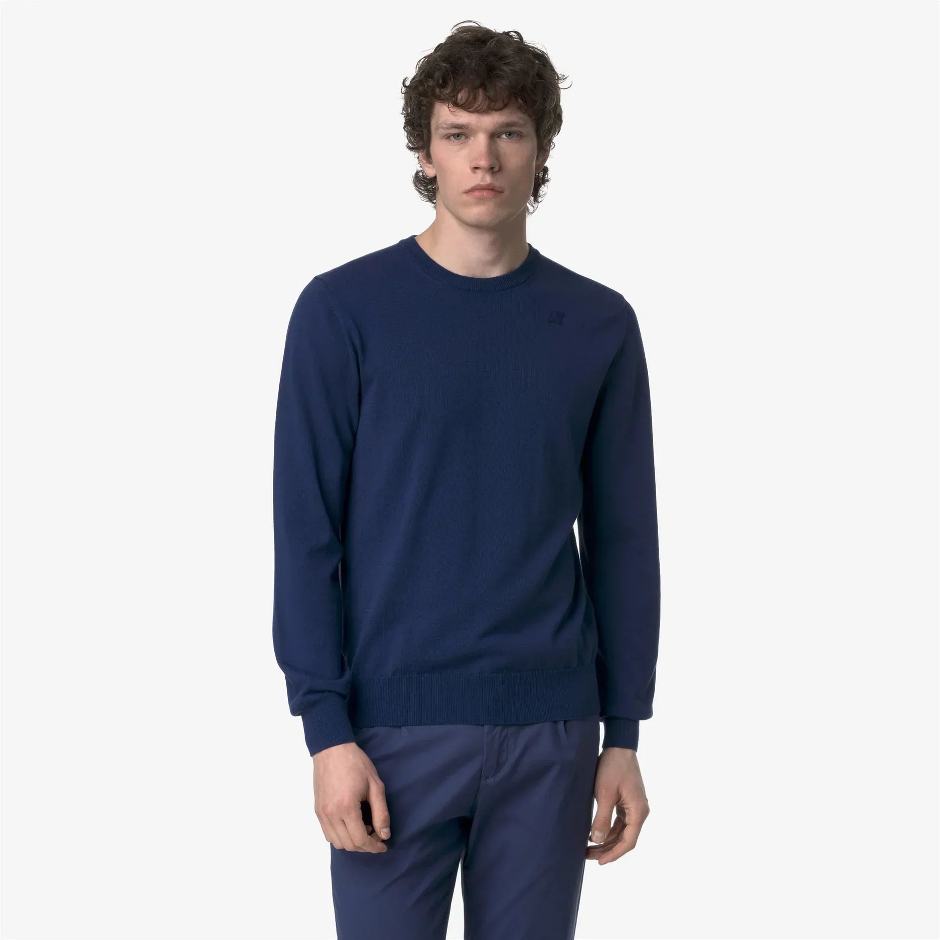 Modello uomo indossa maglione blu girocollo e pantaloni blu, abbigliamento casual elegante
