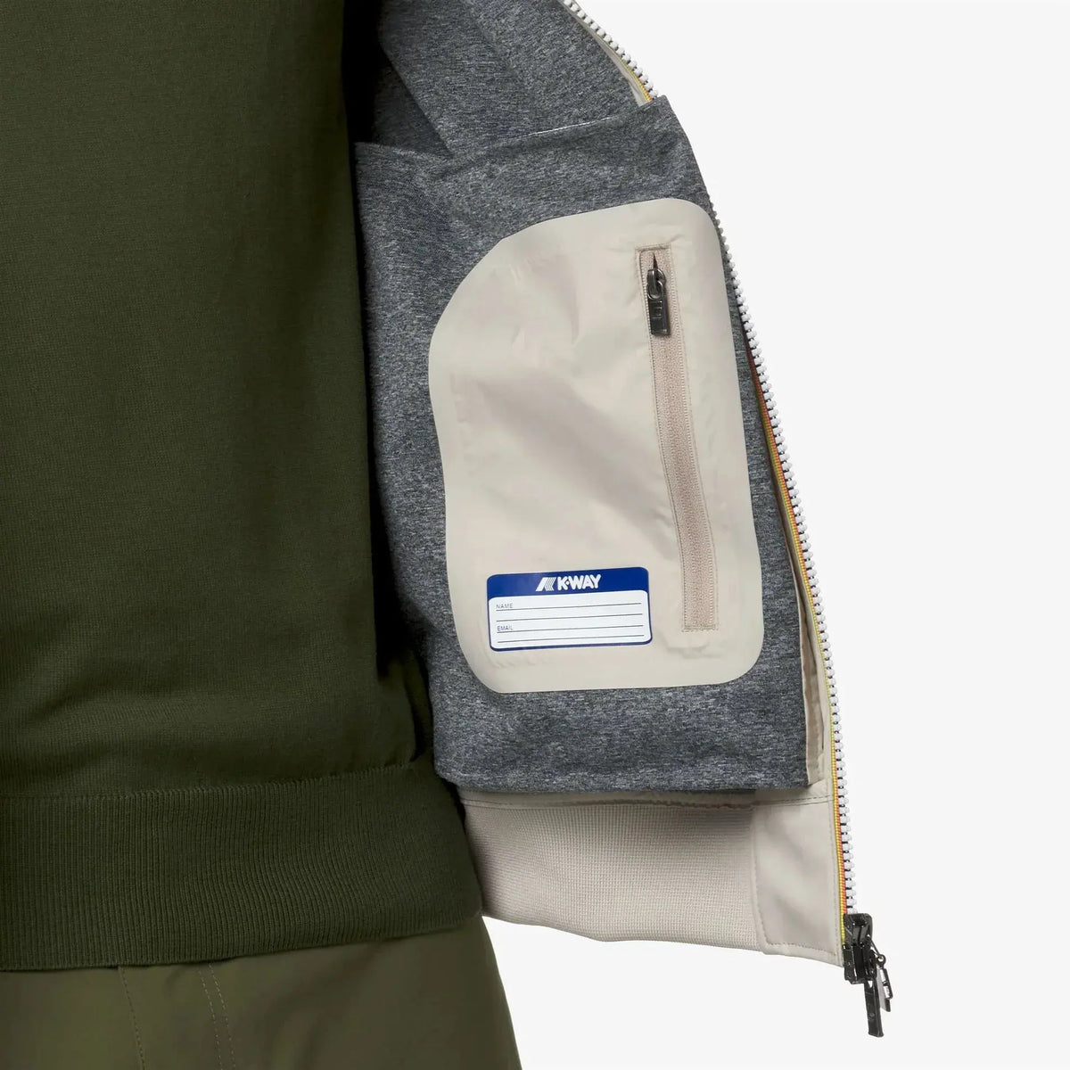 Interno giacca uomo con tasca beige chiusa da zip e dettaglio etichetta, look casual