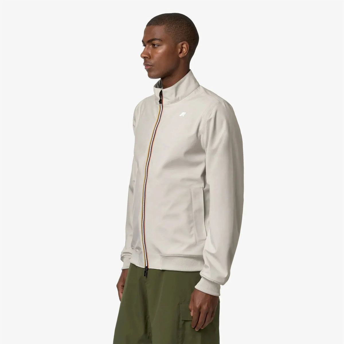 Giubbotto uomo beige con zip colorata, colletto alto e tasche a filetto, stile casual.