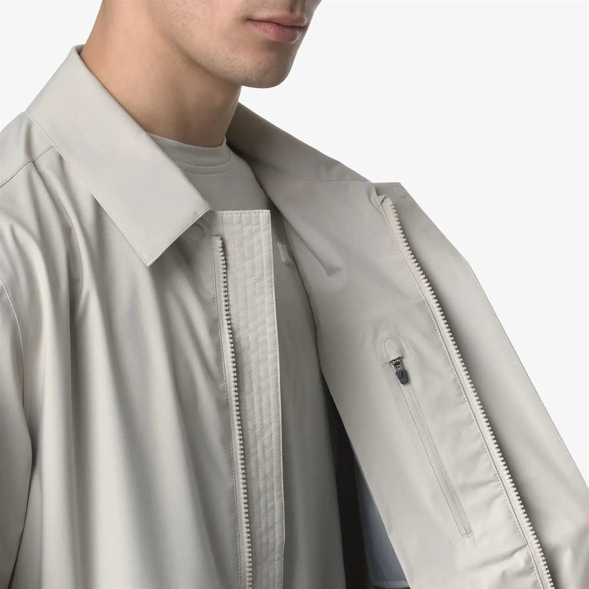Dettaglio giacca uomo beige chiaro con cerniera e tasca interna, moda elegante