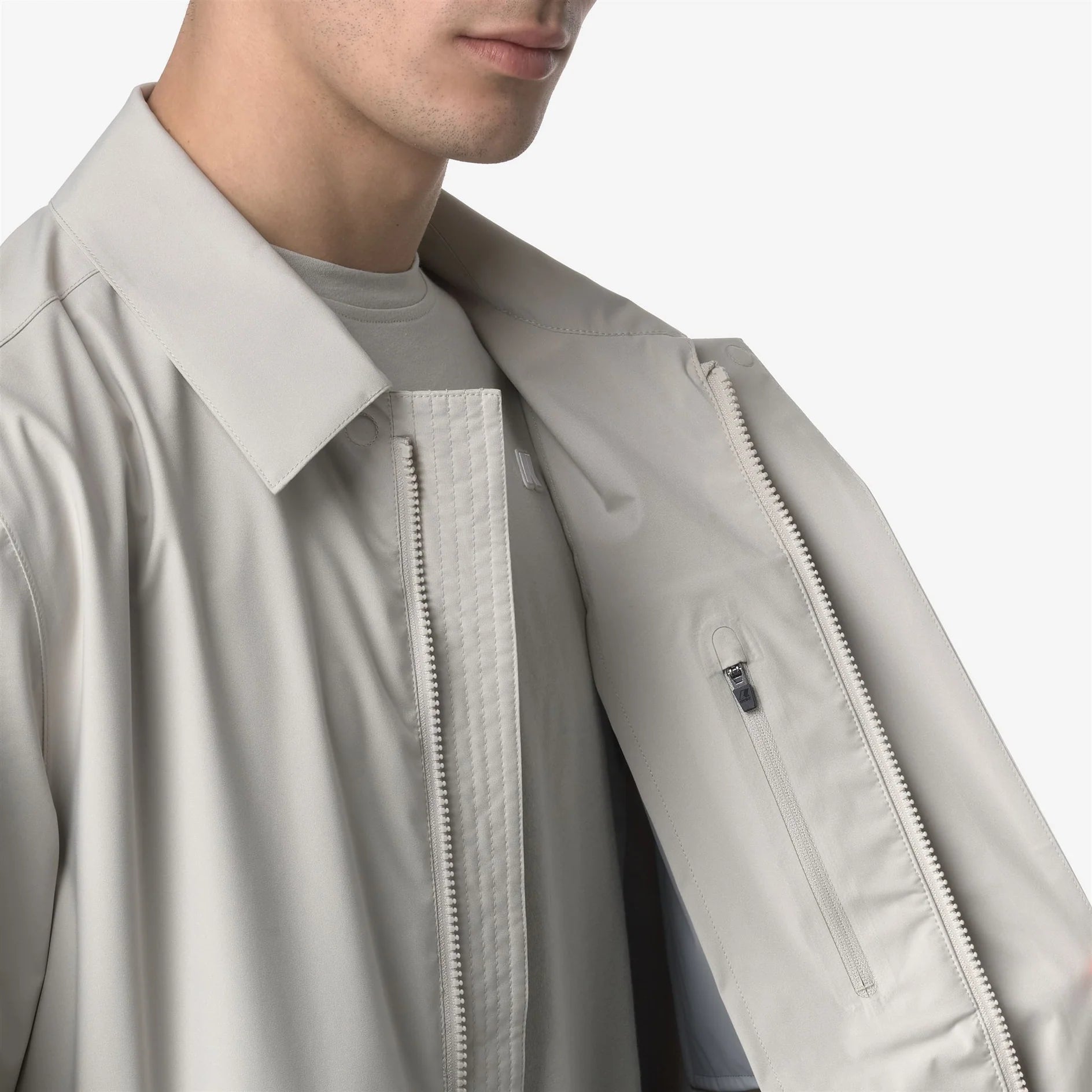 Dettaglio giacca uomo beige chiaro con cerniera e tasca interna, moda elegante