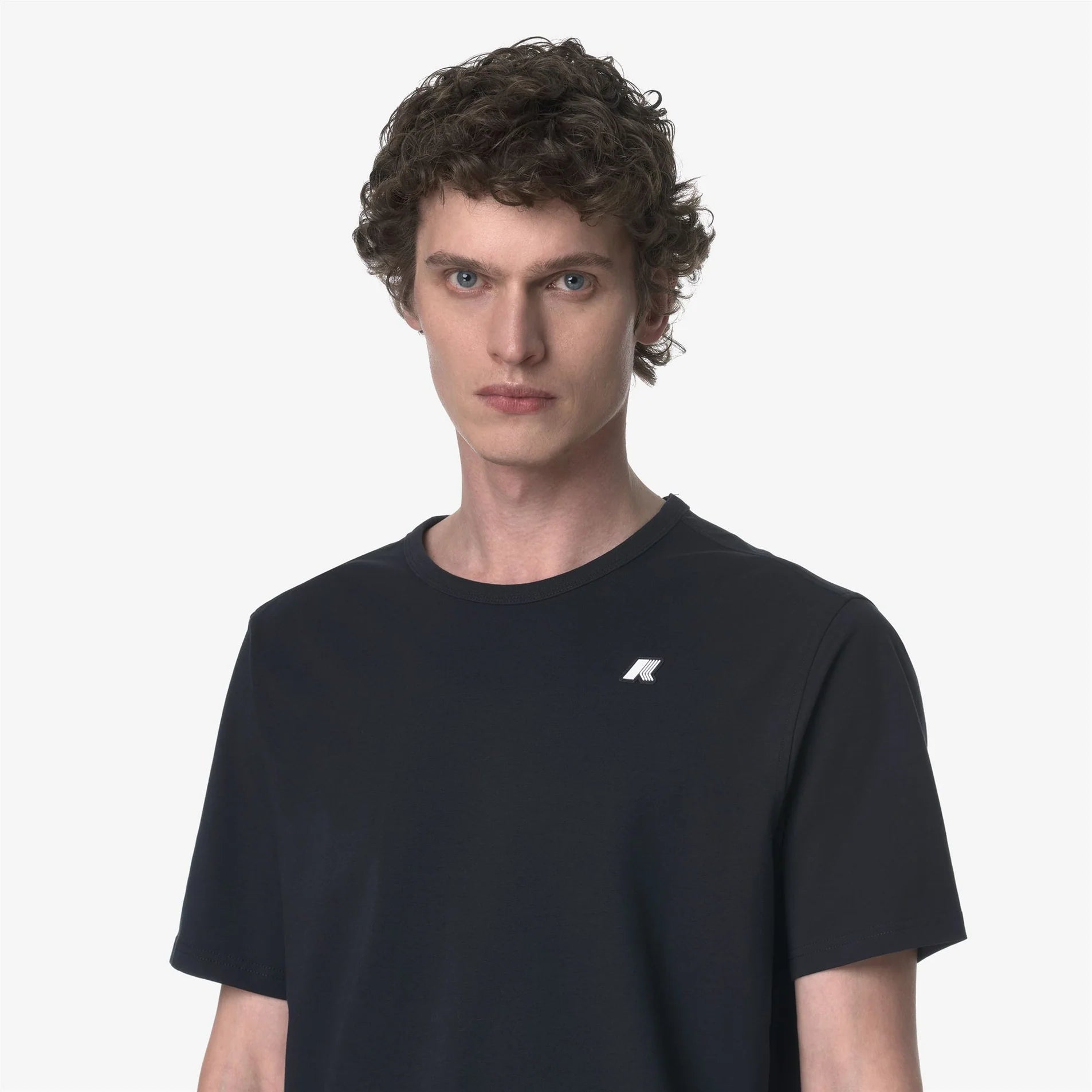 Maglietta uomo nera a maniche corte con piccolo logo bianco sul petto, moda casual.