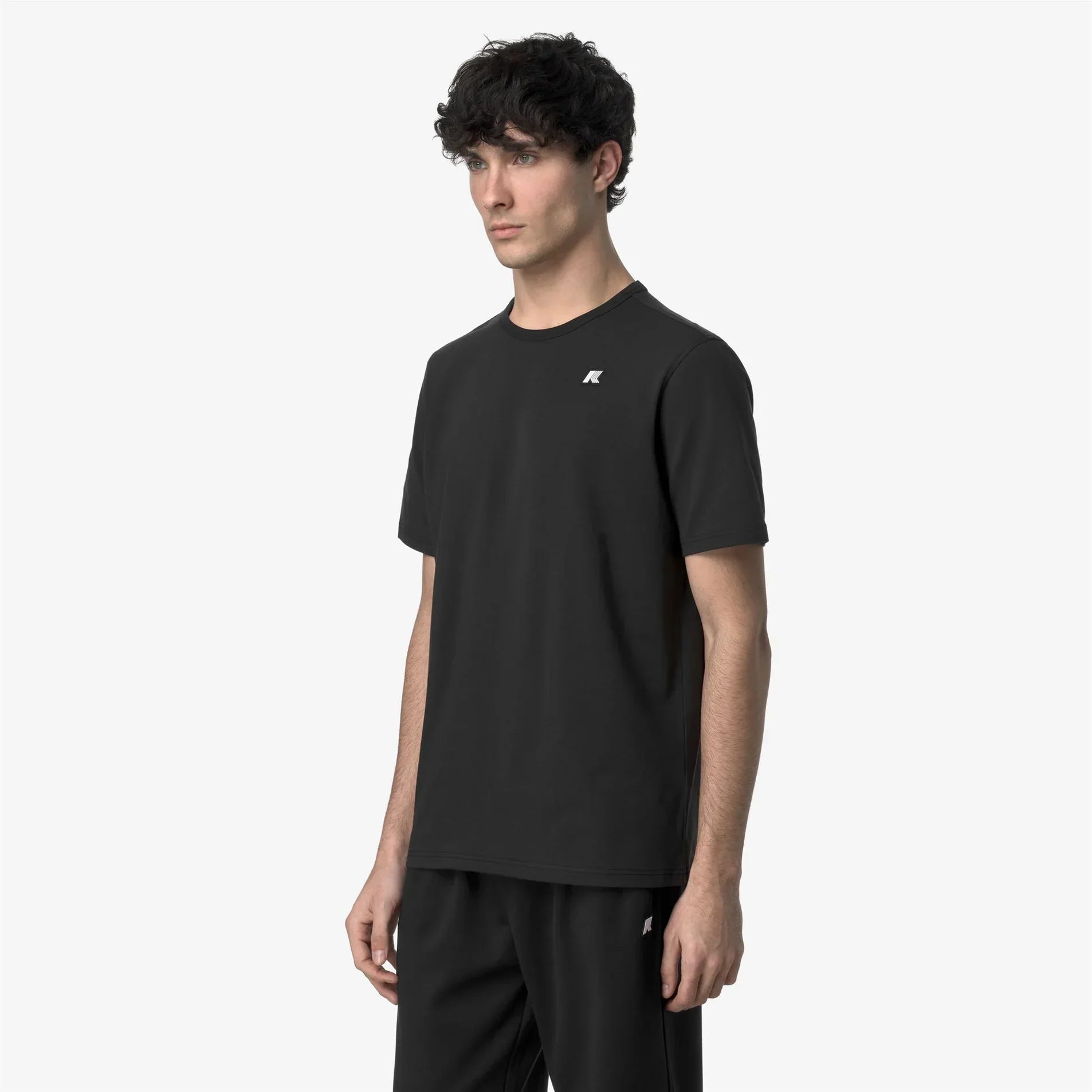 Modello indossa t-shirt nera uomo a maniche corte con logo, stile casual elegante