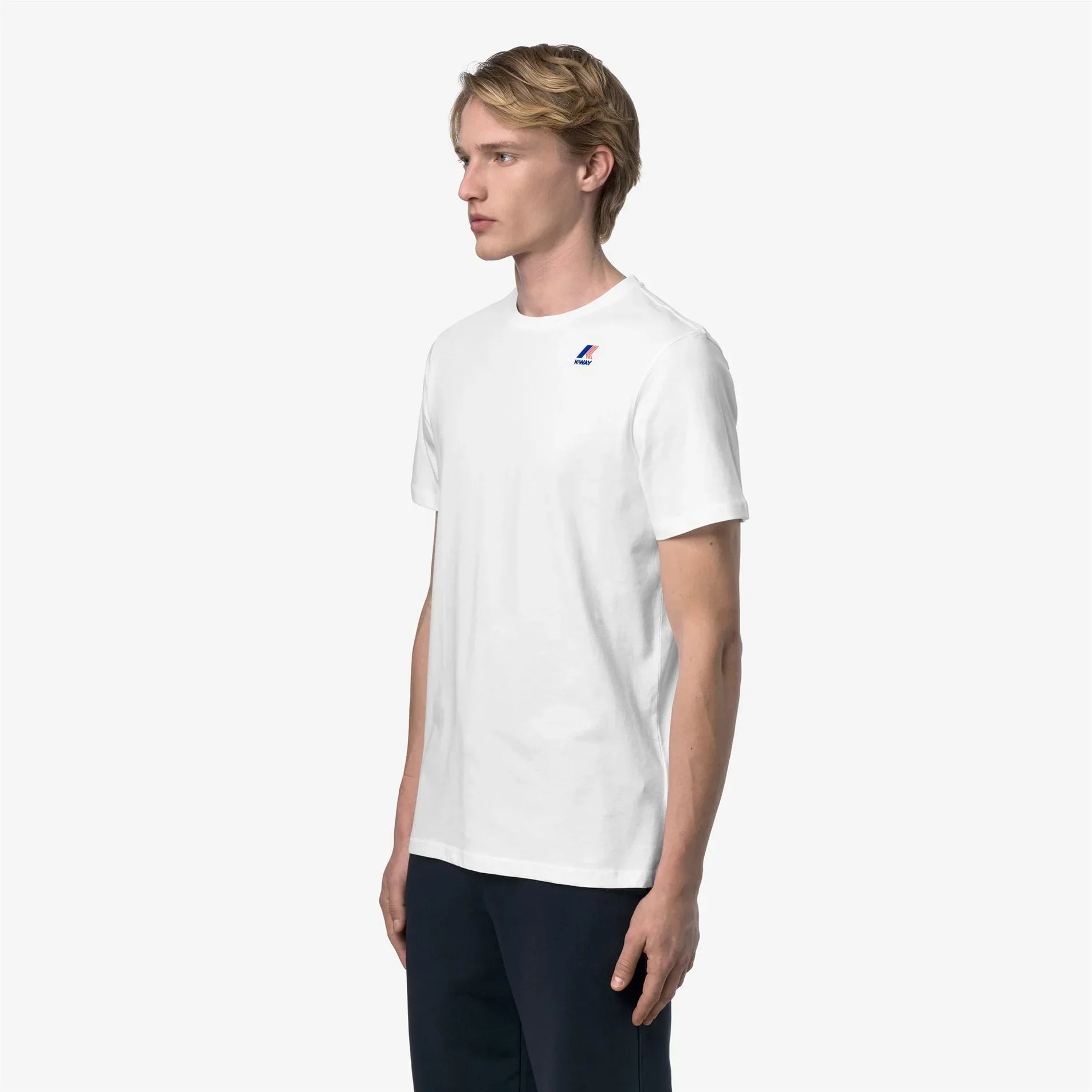 Maglietta uomo bianca manica corta con logo piccolo, look casual, sfondo neutro.