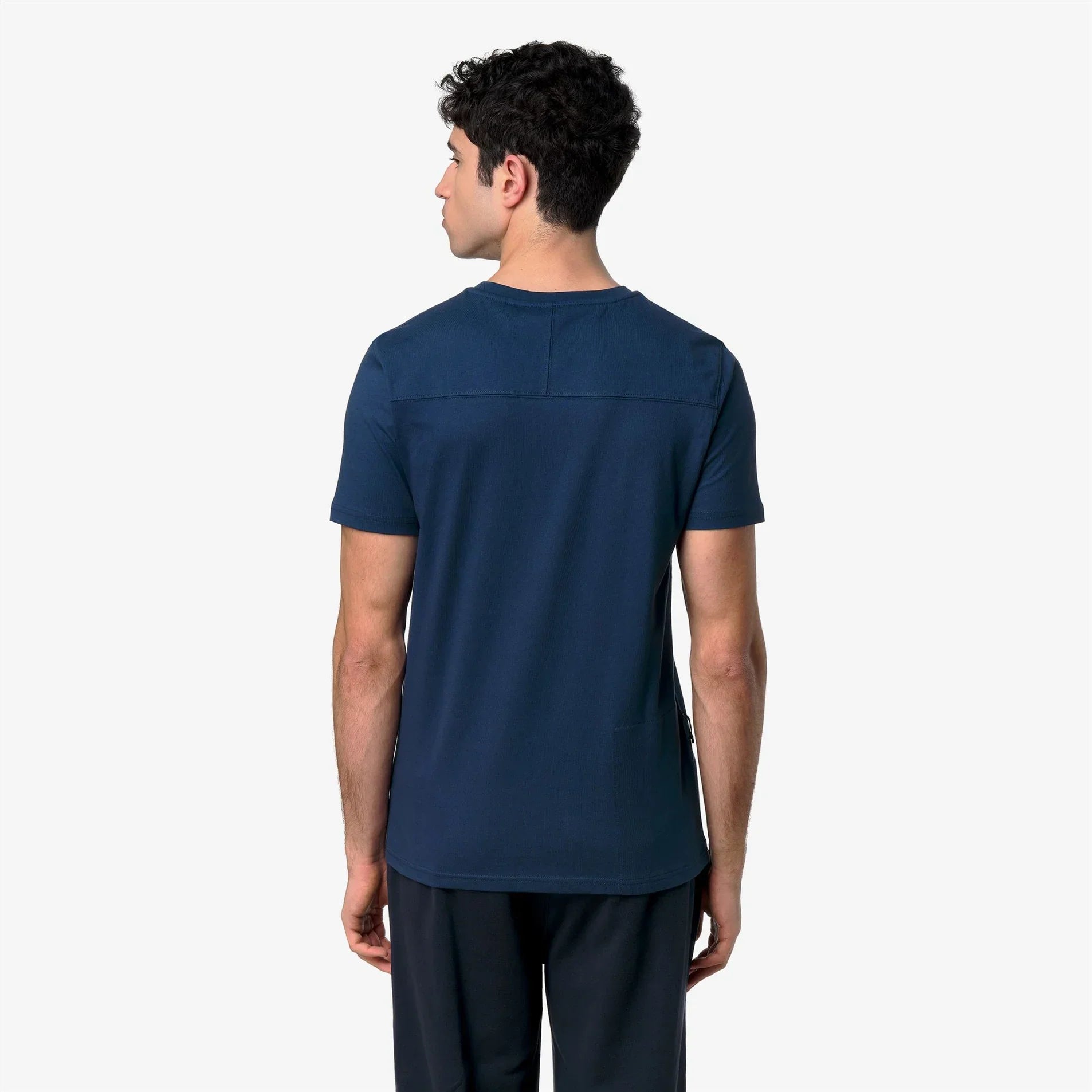 Modello uomo di spalle indossa t-shirt blu navy a maniche corte, stile casual.