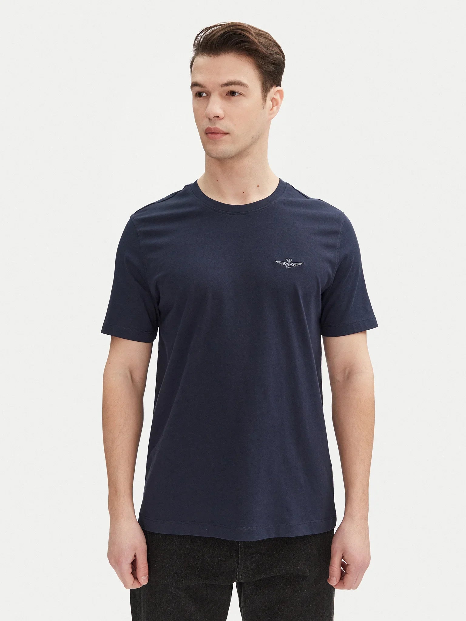 Modello indossa t-shirt basic blu navy da uomo con logo aquila sul petto, stile casual