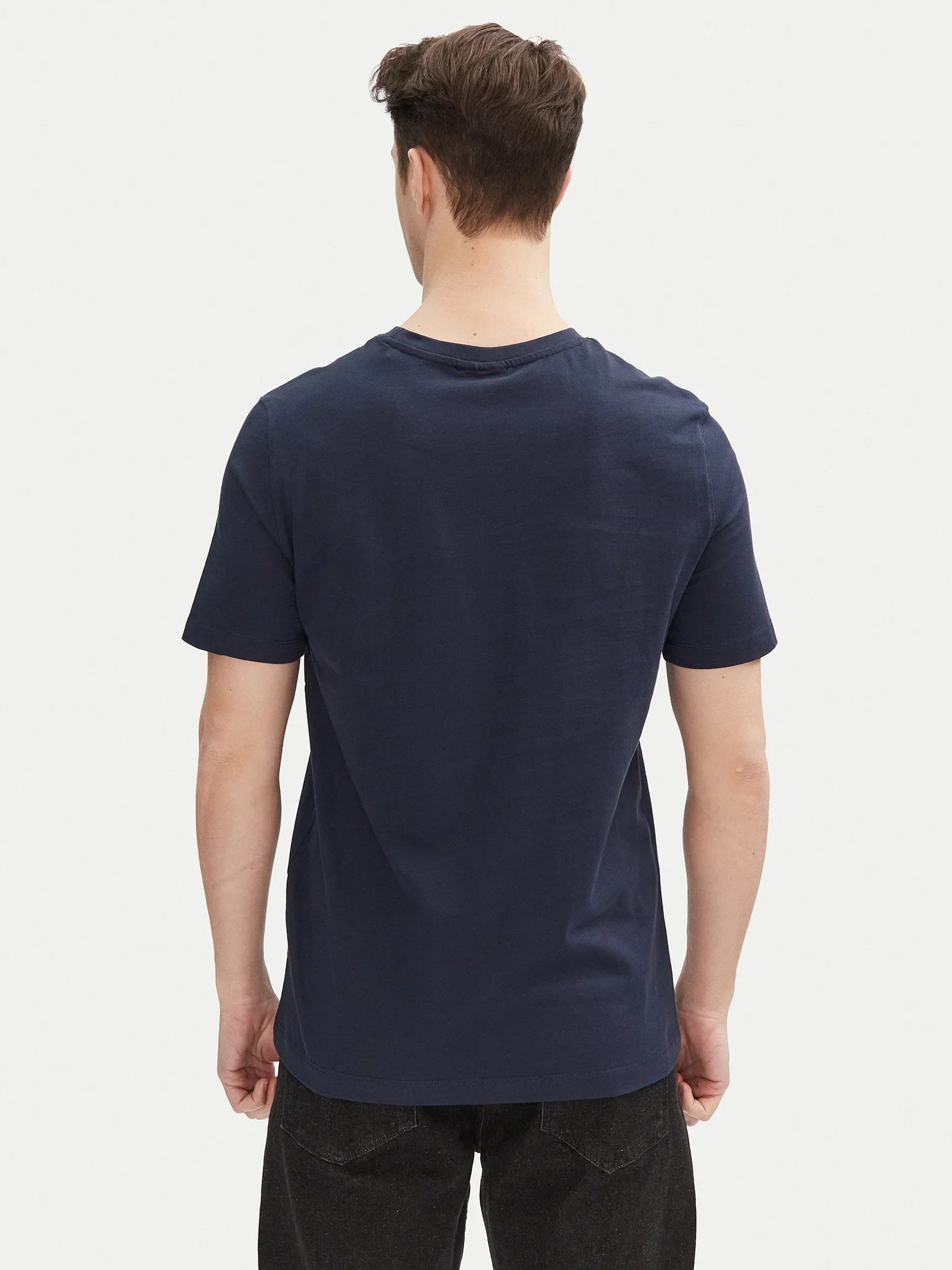Uomo di spalle con t-shirt blu navy basic a maniche corte, stile casual.