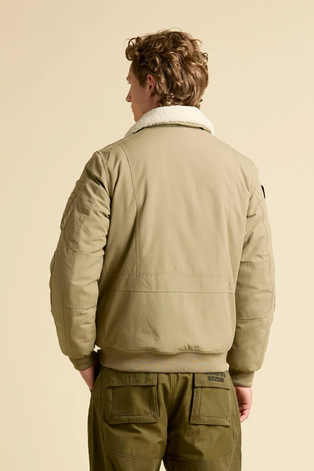 Giubbotto pilot uomo beige con collo in pelliccia e pantaloni verdi, stile aviatore