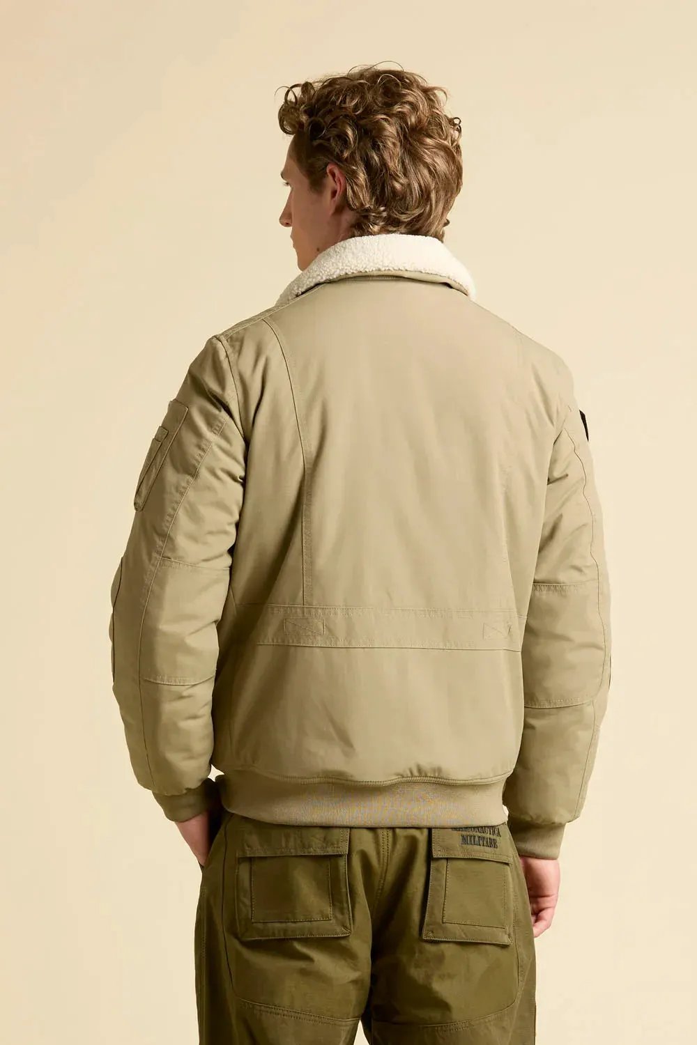 Giubbotto pilot uomo beige con collo in pelliccia e pantaloni verdi, stile aviatore
