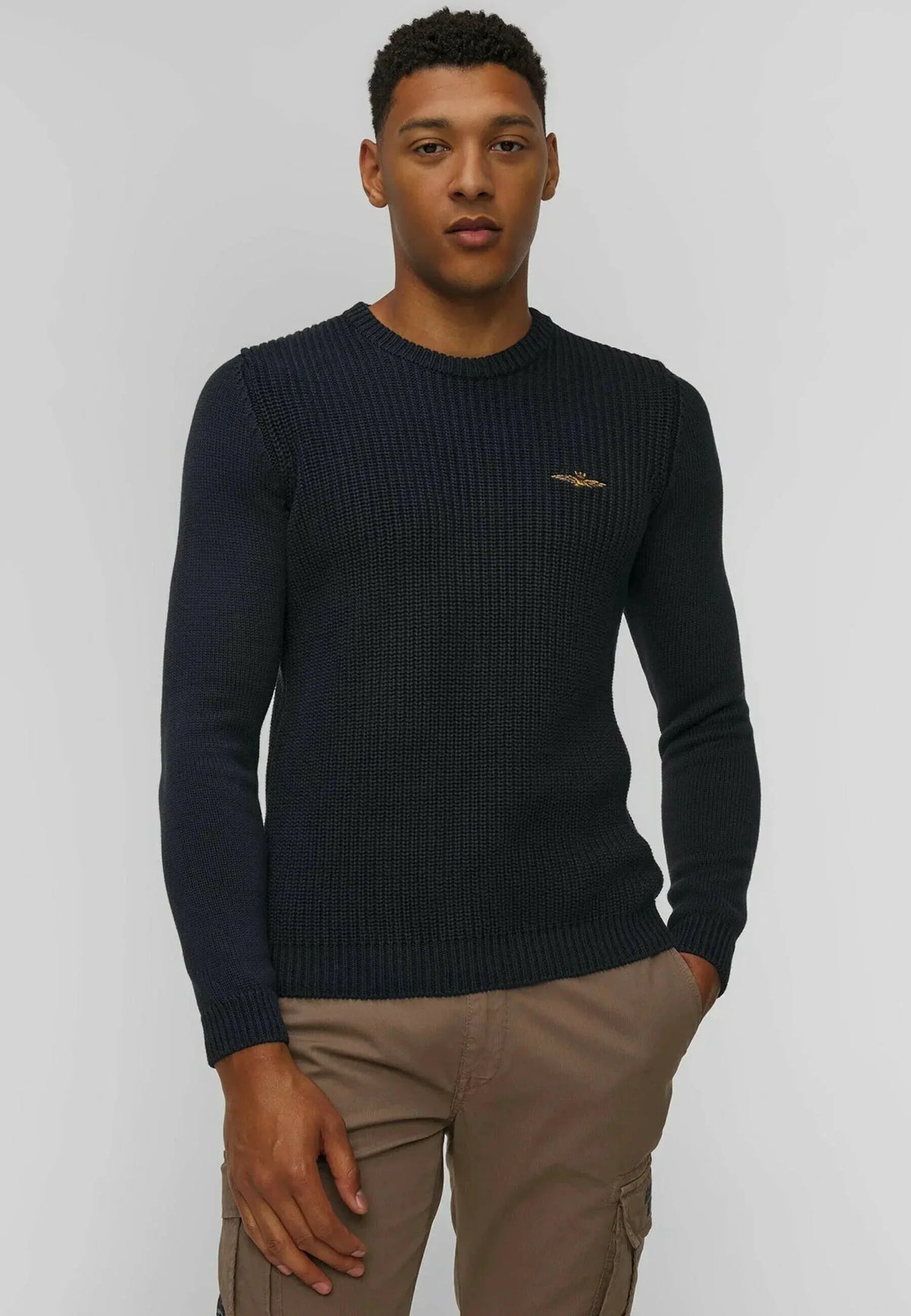 Maglione uomo blu scuro in lana merino a girocollo, dettaglio logo dorato, look casual.