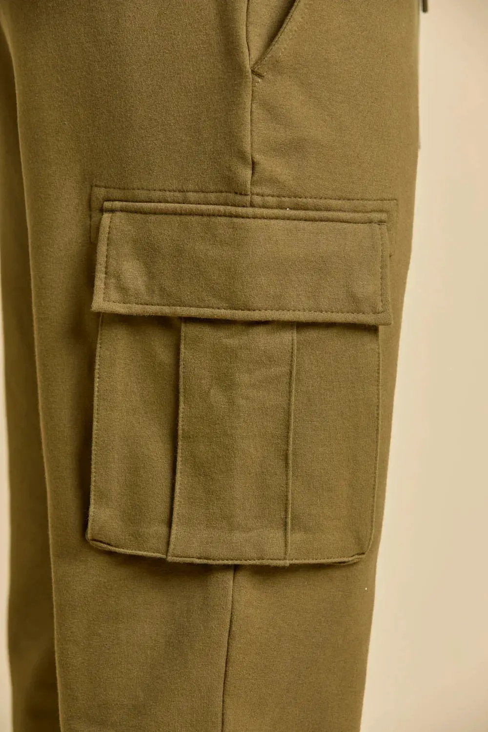Dettaglio pantalone cargo felpa cotone verde oliva con tasca laterale uomo
