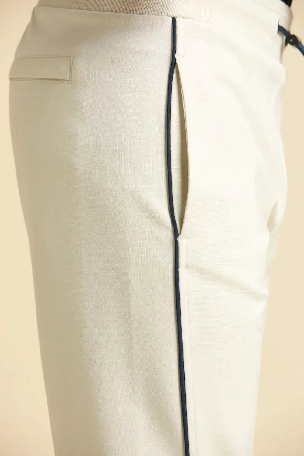 dettaglio pantalone sportivo uomo ghiaccio con piping blu e tasca laterale