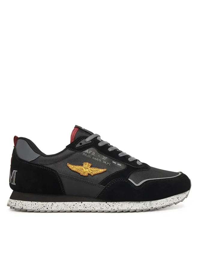 Sneaker nera da uomo con dettagli dorati, suola maculata e logo ricamato laterale
