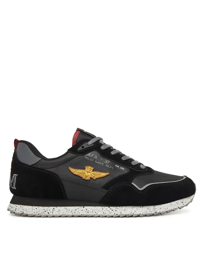 Sneaker nera da uomo con dettagli dorati, suola maculata e logo ricamato laterale