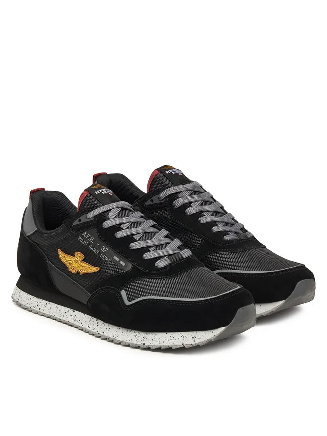 Sneakers nere uomo con dettagli dorati, logo ala laterale e suola bianca maculata
