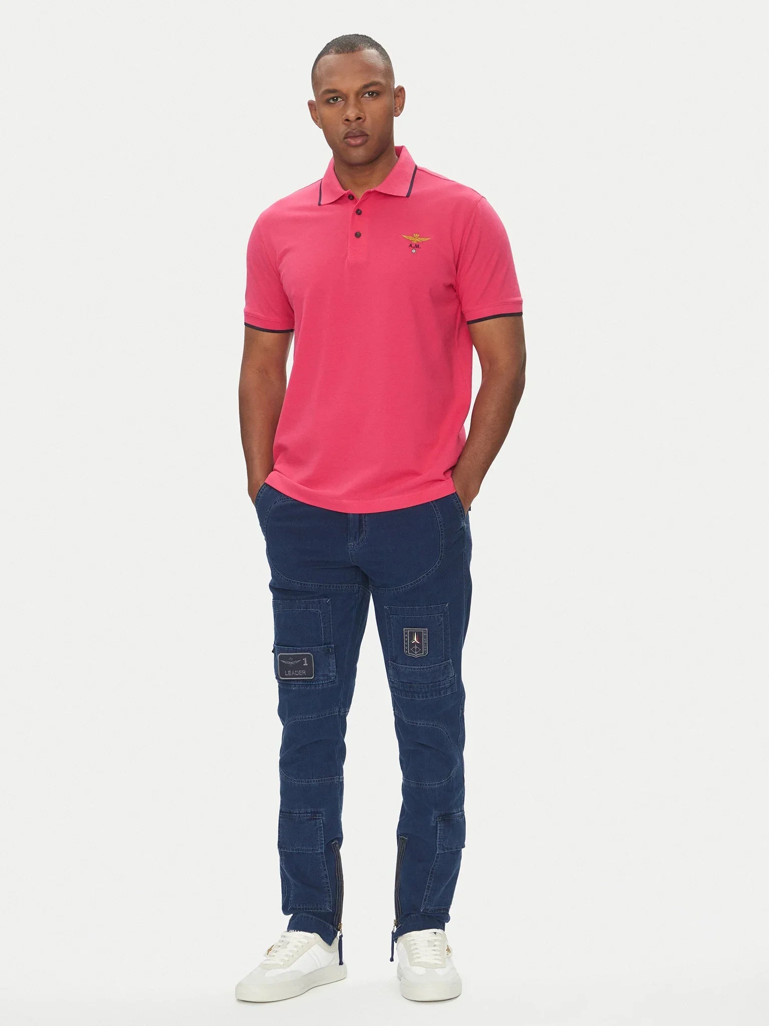 Modello con polo magenta manica corta in cotone e pantaloni cargo blu, stile casual uomo.
