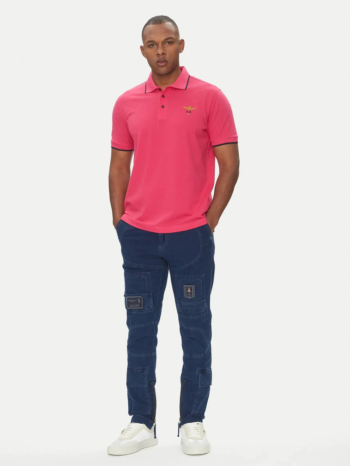 Modello con polo magenta manica corta in cotone e pantaloni cargo blu, stile casual uomo.