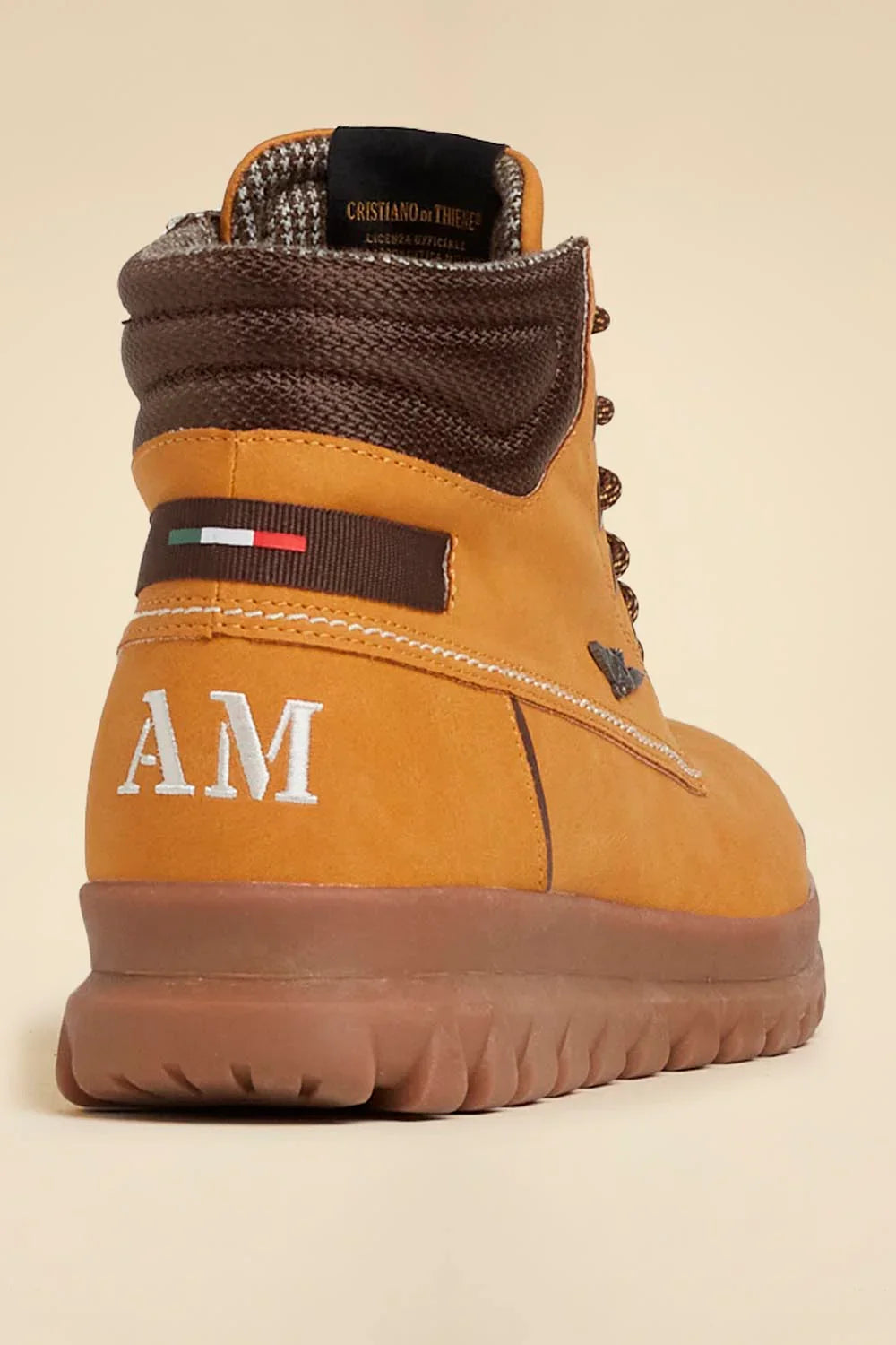 Stivaletto uomo beige con dettagli marroni, suola alta, logo AM e bandiera italiana sul tallone.
