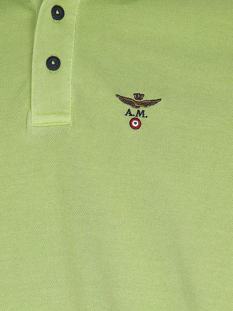 Dettaglio polo verde chiaro da uomo con logo ricamato e chiusura a tre bottoni.