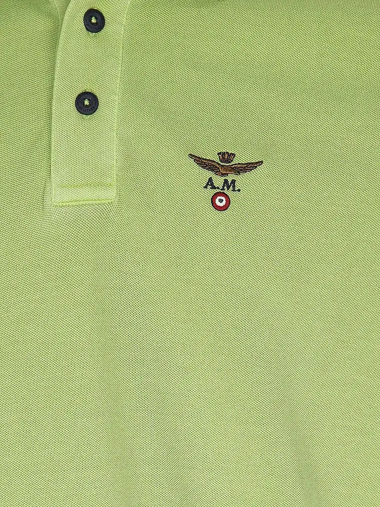 Dettaglio polo verde chiaro da uomo con logo ricamato e chiusura a tre bottoni.