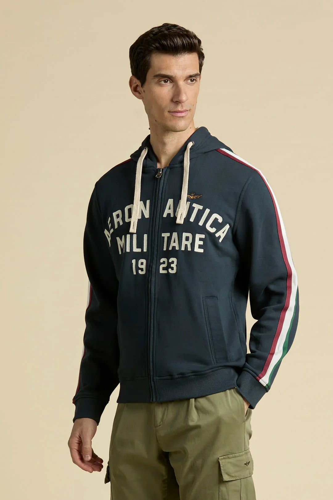 Felpa Aeronautica Militare blu navy full zip con cappuccio, scritta bianca 1923 e bande tricolore rosso, bianco e verde sulle maniche.