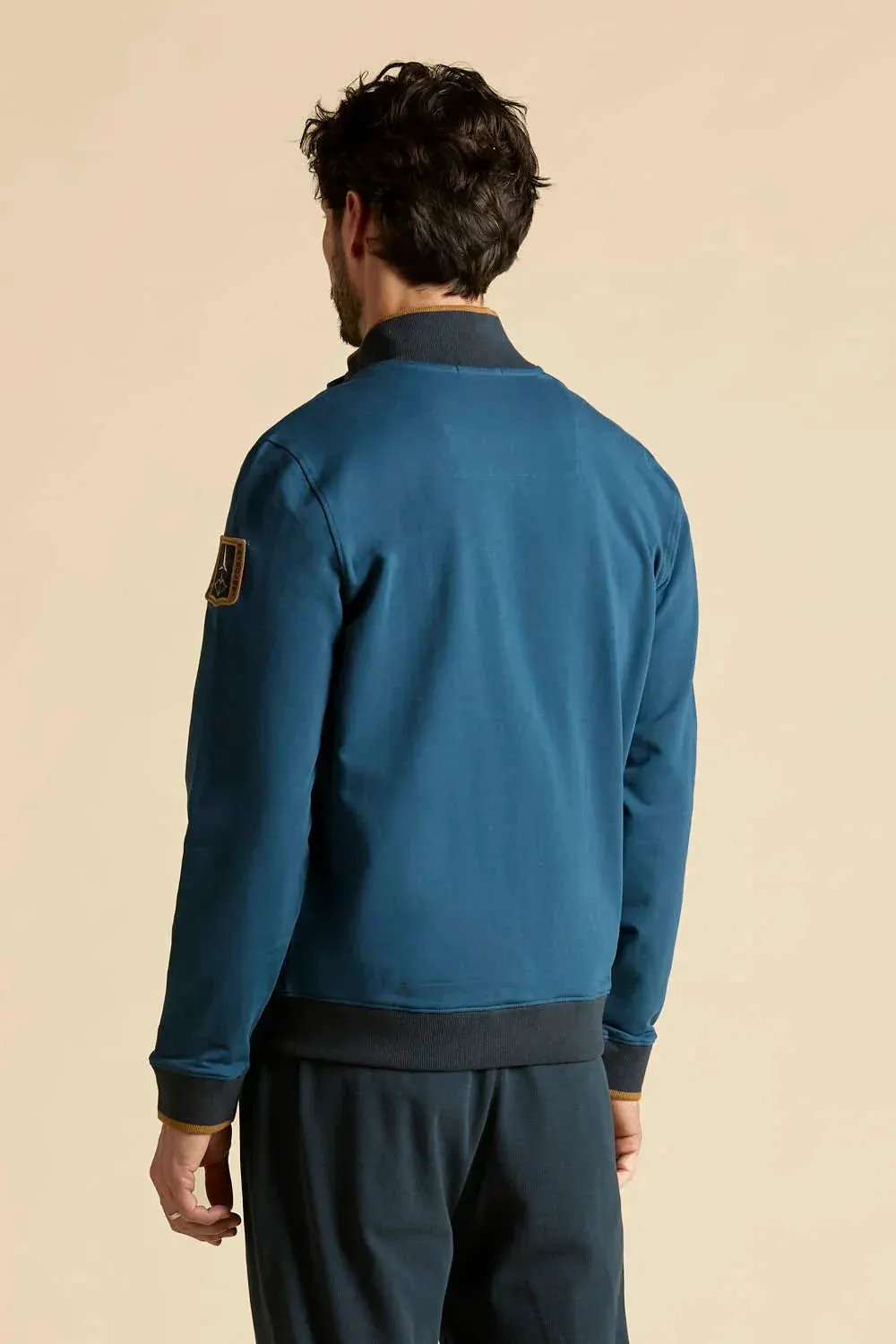 Felpa uomo blu zip intera, vista posteriore, dettaglio patch sulla manica sinistra