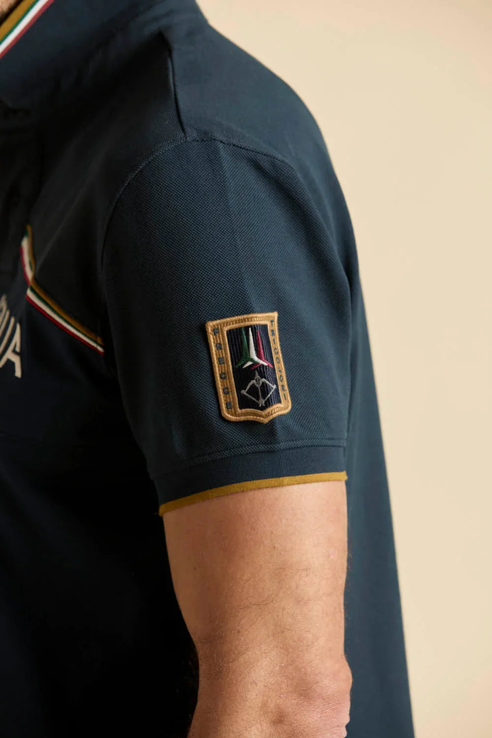 Polo blu uomo con patch Frecce Tricolori sulla manica e dettagli tricolore.