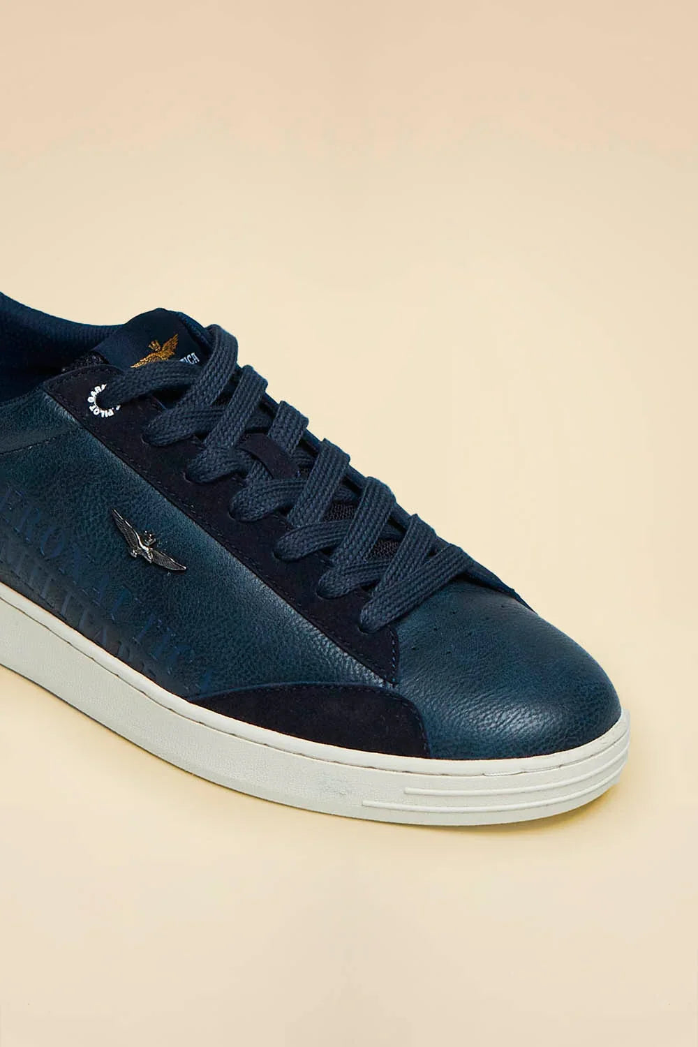 Sneaker low-top blu in similpelle con suola bianca e dettagli a rilievo, stile casual uomo.