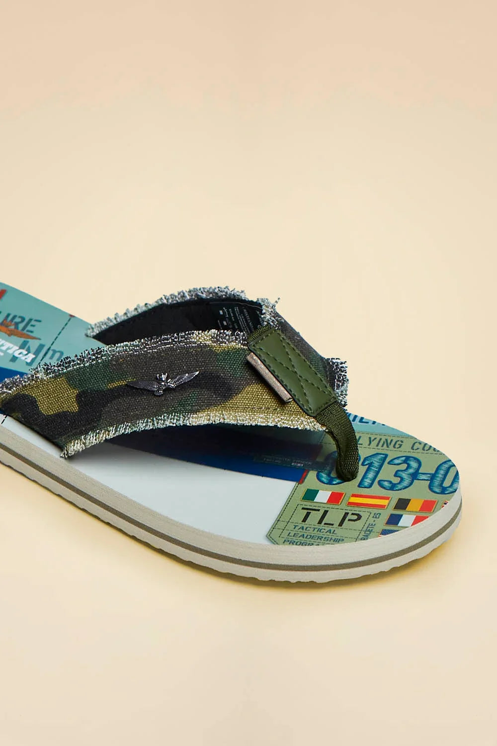 Infradito uomo in tessuto canvas camouflage con dettagli patch militari e suola stampata.