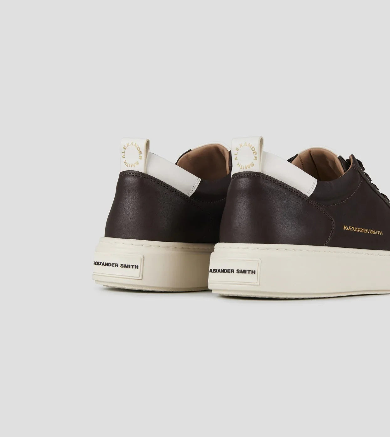 Sneaker uomo in pelle marrone scuro con suola bianca, dettagli logo laterali e sul tallone.