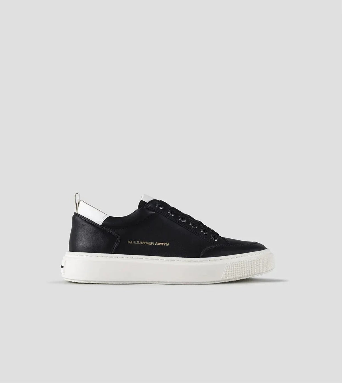 Sneaker uomo nera con suola bianca, dettagli bianchi e logo laterale dorato, stile casual.