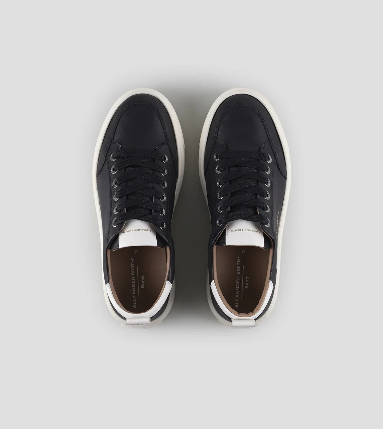 Sneakers uomo nere con dettagli bianchi, suola bianca, stile casual elegante.
