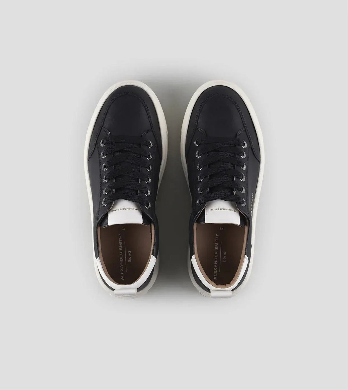 Sneakers uomo nere con dettagli bianchi, suola bianca, stile casual elegante.