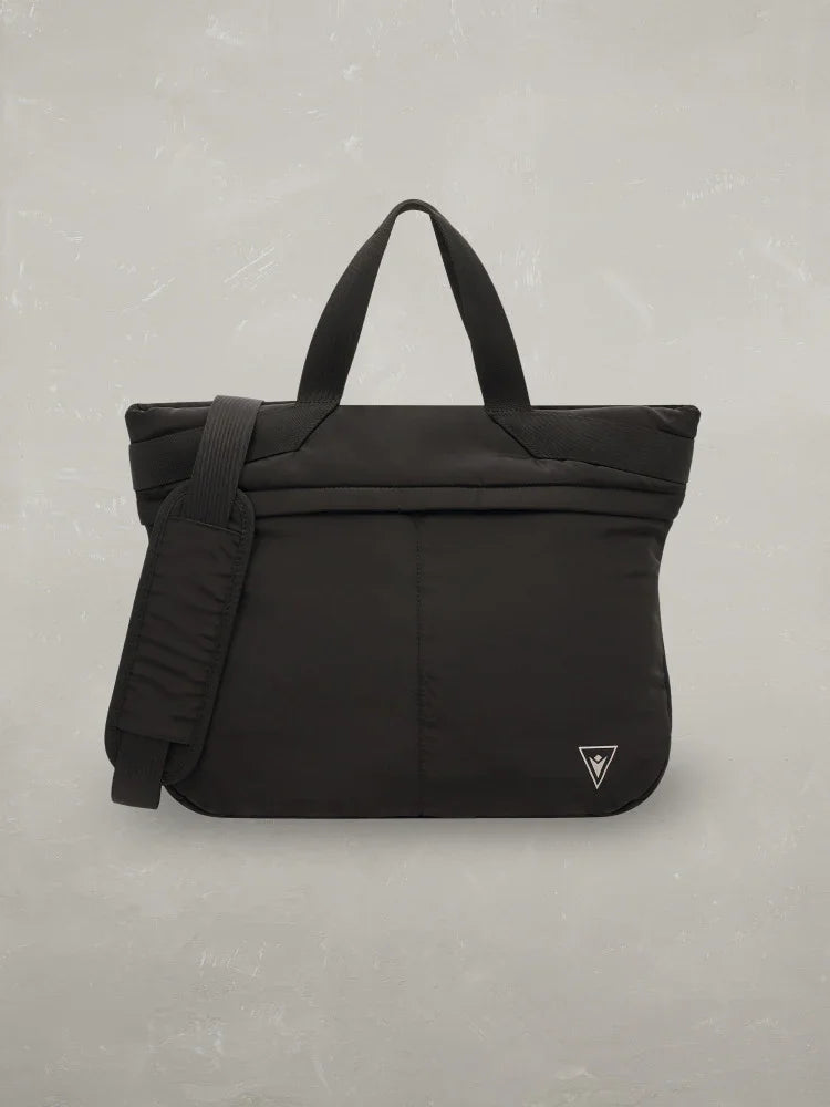 Borsa shopper nera uomo donna con manici, tracolla e logo triangolare su sfondo grigio.