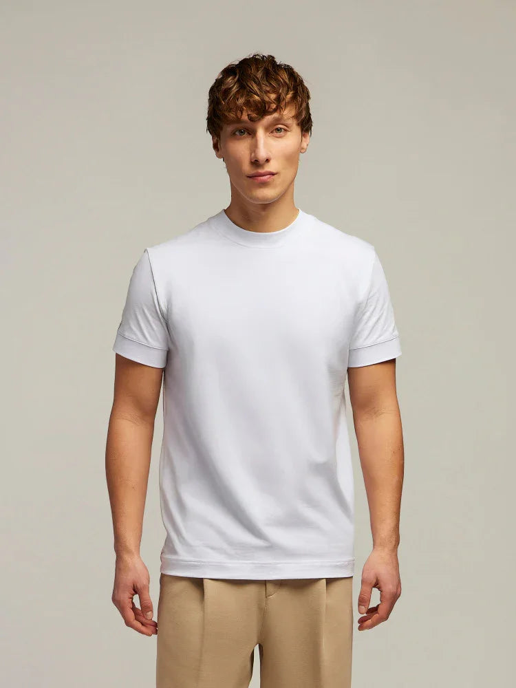 Modello uomo indossa t-shirt bianca a manica corta e pantaloni beige, moda casual elegante.
