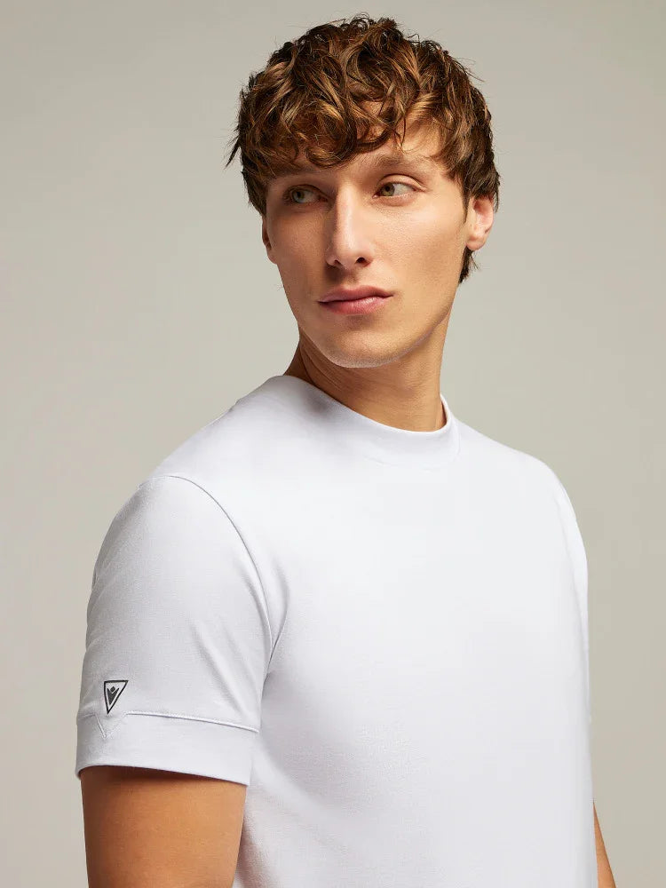 Modello uomo indossa t-shirt bianca a maniche corte con logo piccolo sulla manica, moda uomo casual