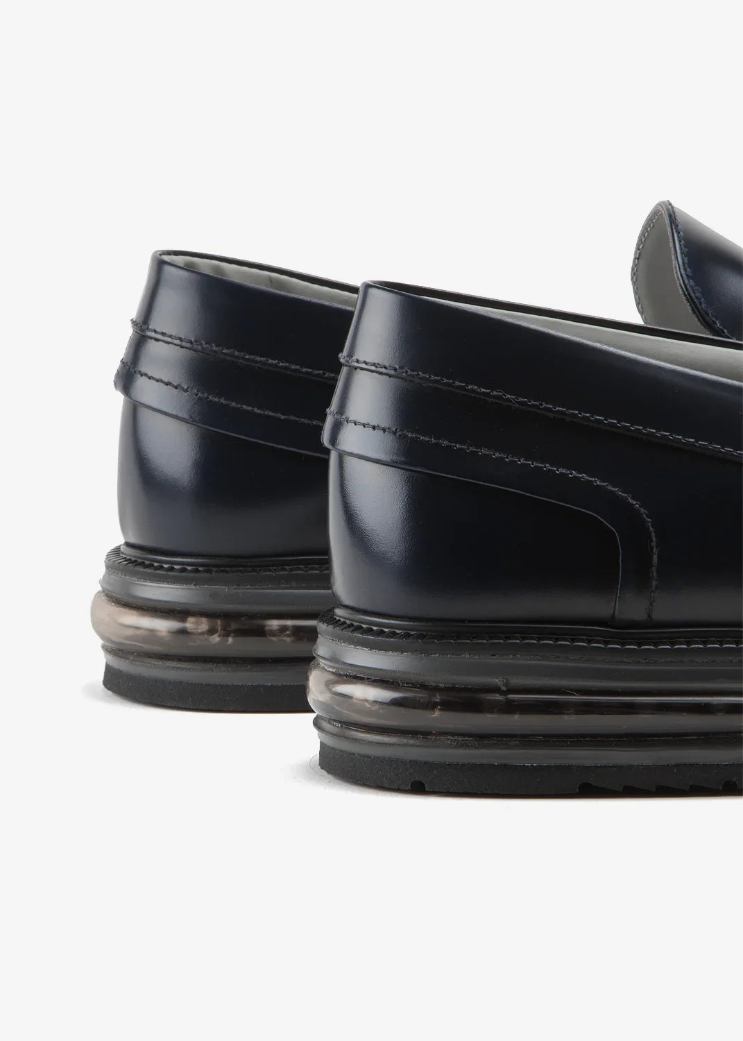 Dettaglio mocassino uomo blu in pelle con suola trasparente moderna