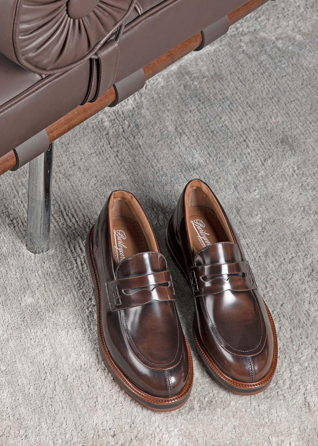 Mocassini uomo in pelle marrone lucida su pavimento grigio, stile elegante Made in Italy
