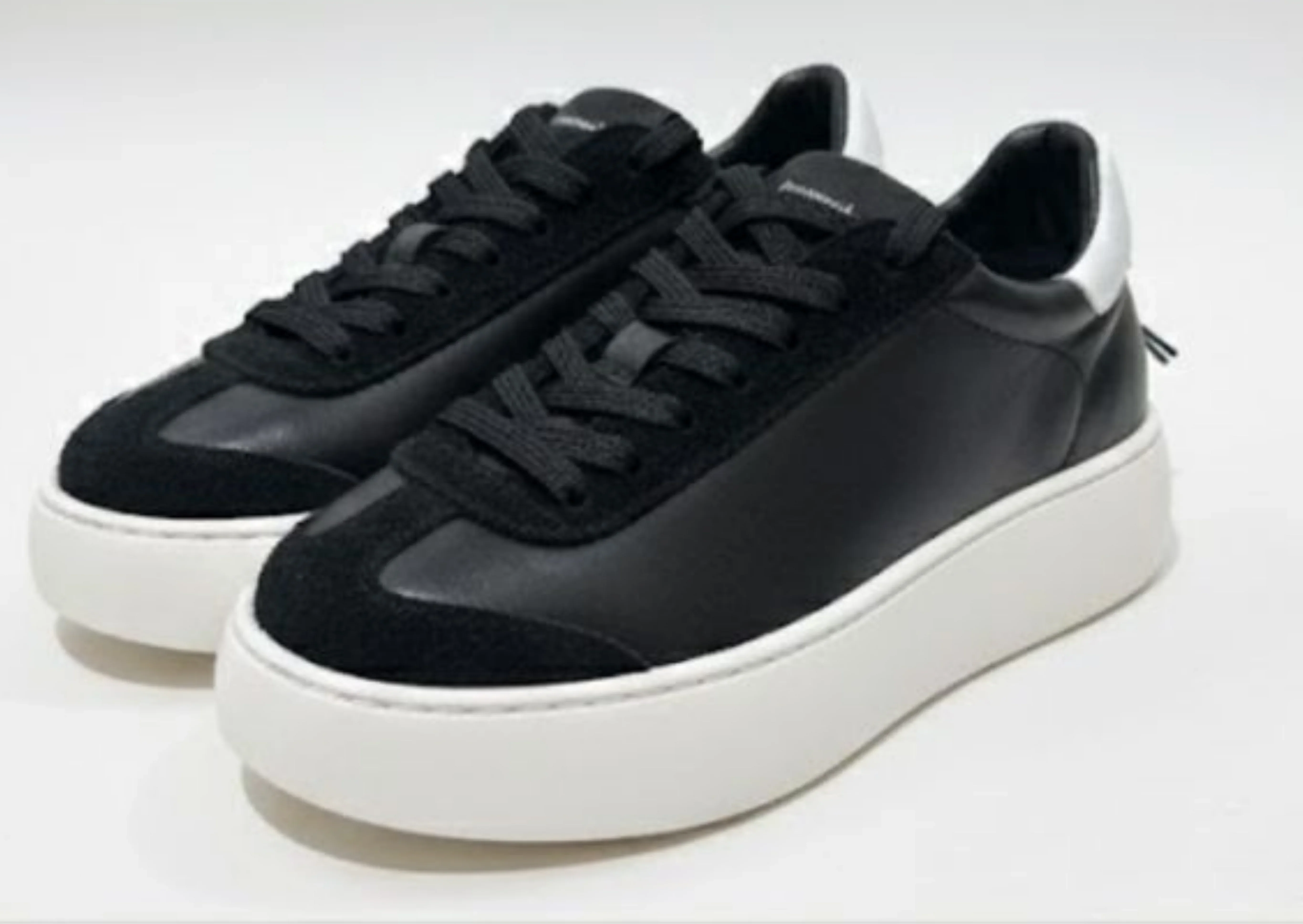 Sneaker uomo nera con suola bianca alta, design moderno e tomaia in pelle liscia.