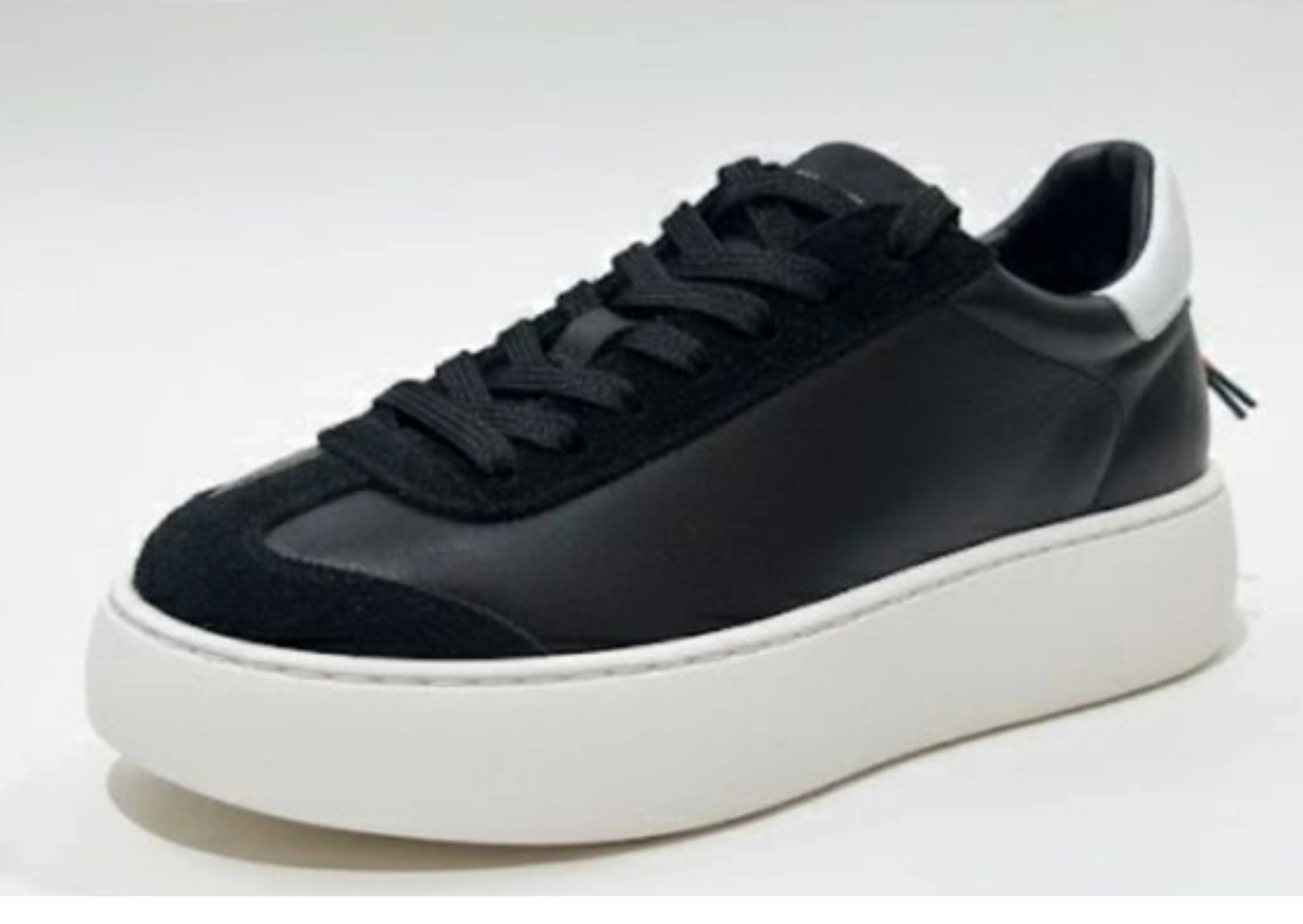 Sneaker nera da uomo con suola platform bianca, dettagli minimal, stile moderno