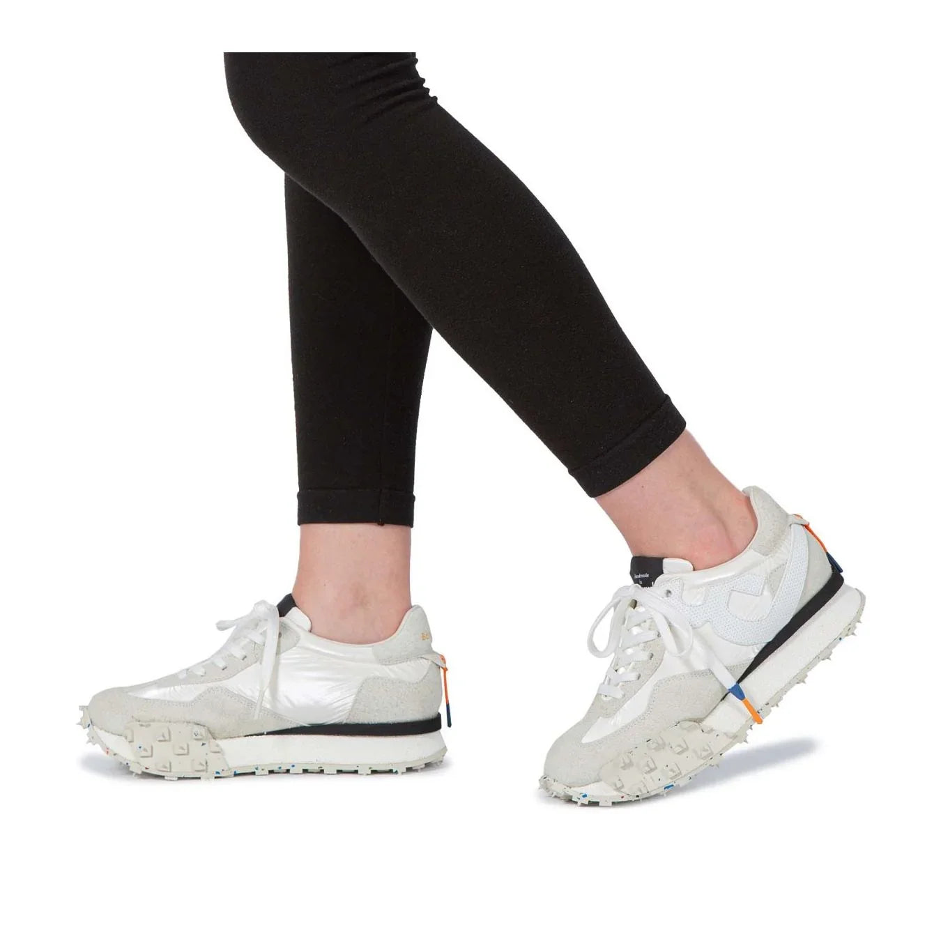 Sneakers bianche da donna con dettagli beige e suola carrarmato, indossate con leggings neri