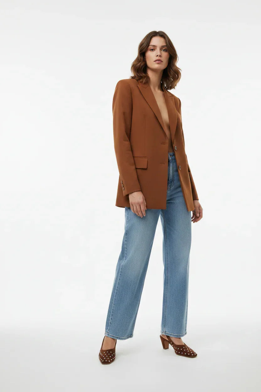 Donna con blazer marrone, jeans a gamba larga e décolleté marroni a pois, moda elegante