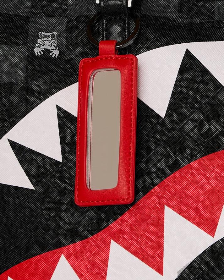 Portachiavi rosso su borsa nera con motivo grafico a denti bianchi e rossi