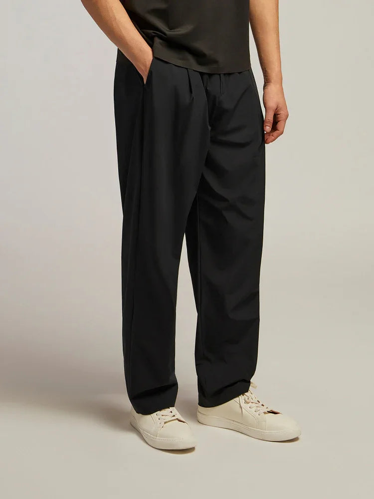 Pantaloni uomo neri eleganti a gamba larga, abbinati a sneakers bianche, moda uomo