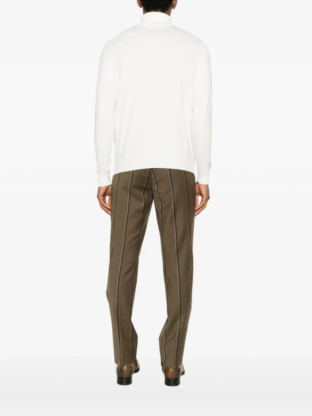 Maglione dolcevita uomo bianco, pantaloni marroni a righe, look elegante di spalle.